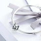 Bulldog face charm bead on a silver snake chain bracelet with a light ribbon bow