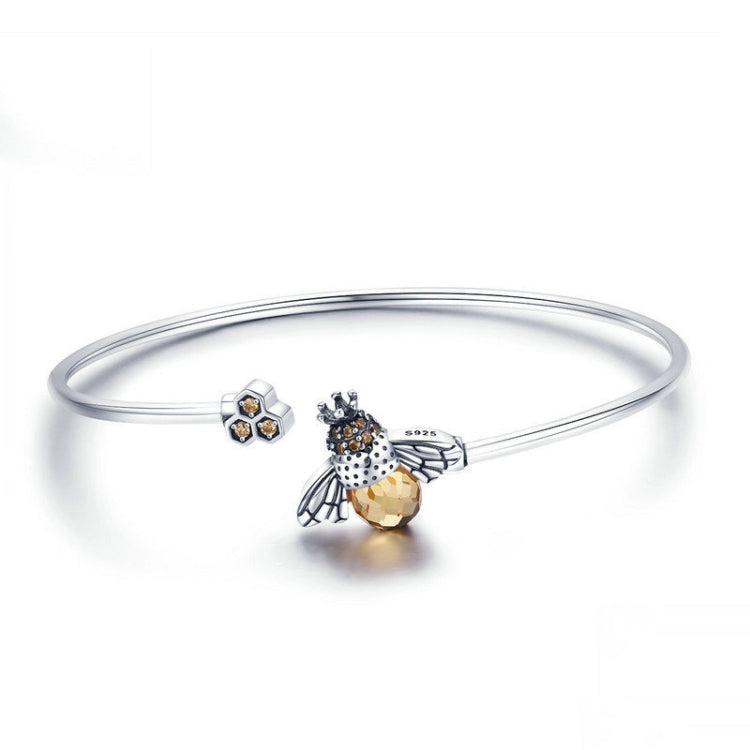 Sterling silver bangle bracelet with bee charm and small flower stud accents