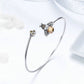Sterling silver bracelet with bee and honeycomb charms, open bangle design
