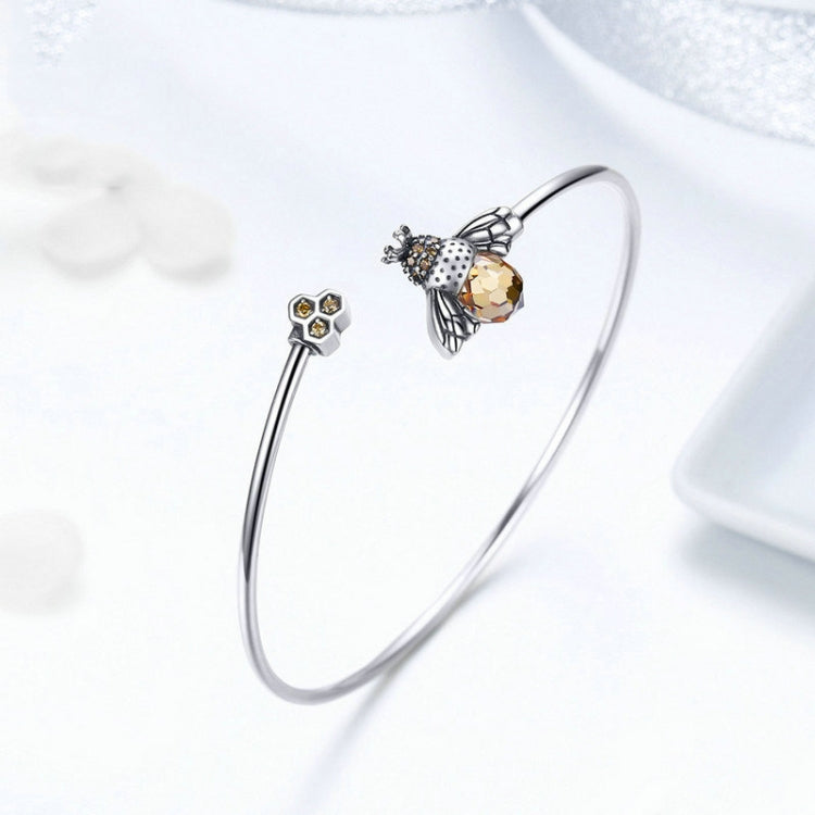Sterling silver bracelet with bee and honeycomb charms, open bangle design