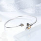 Sterling silver bangle bracelet featuring bee charm with faceted yellow bead
