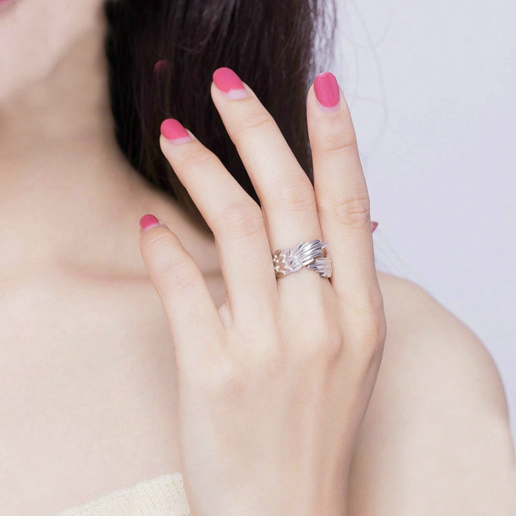 Feather-wing adjustable silver S925 ring on hand with pink nail polish