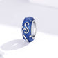 Blue star-glow enamel bead charm with silver swirl S pattern, side view