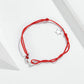 Red string bracelet with sterling silver star charm and small silver charm at clasp