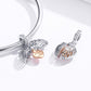 Two sterling silver angel wing heart charms on a snake bracelet with rose-gold heart centers