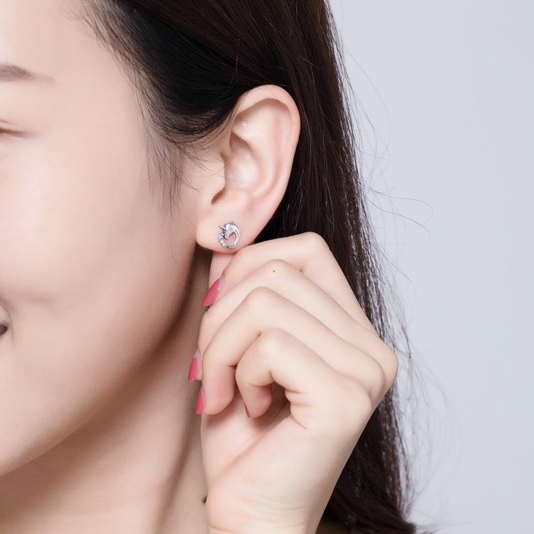 Silver stud earring with colored zircon on a woman's ear