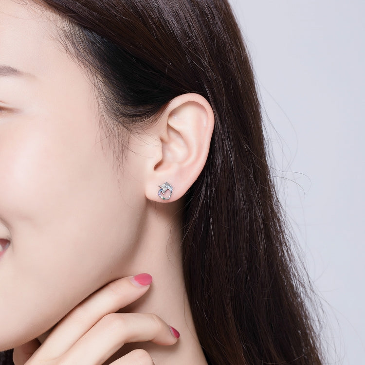 Silver stud earrings with colored zircon on model's ear