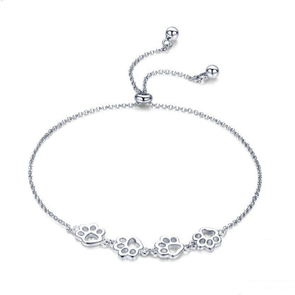 Sterling silver paw print charm bracelet with dangling paw motif on chain