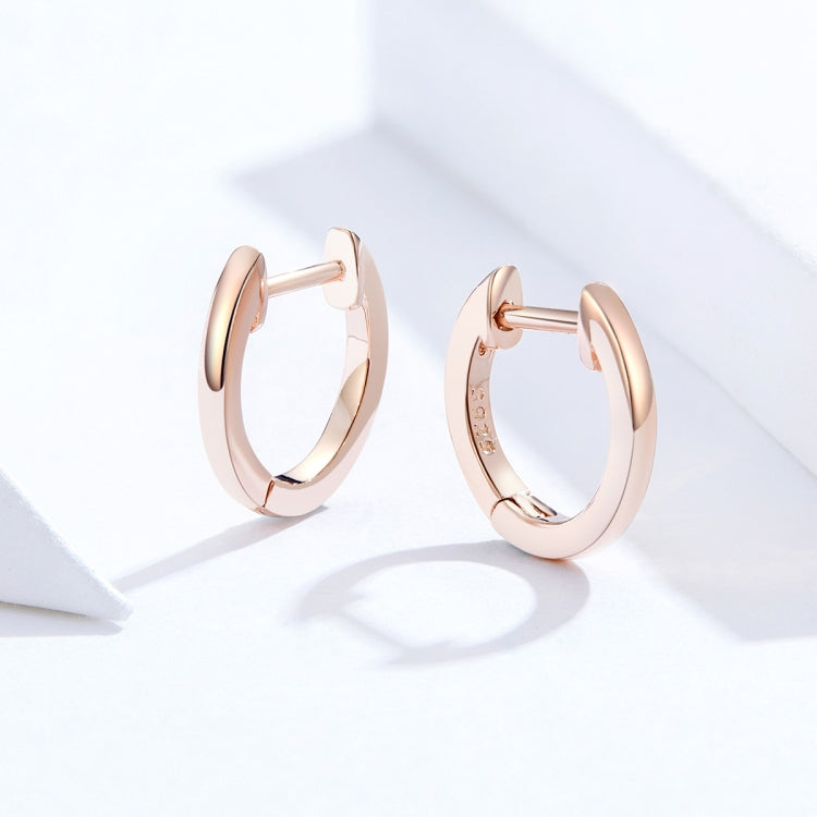 Rose gold hoop earrings with hinged back, circular profile, polished metal