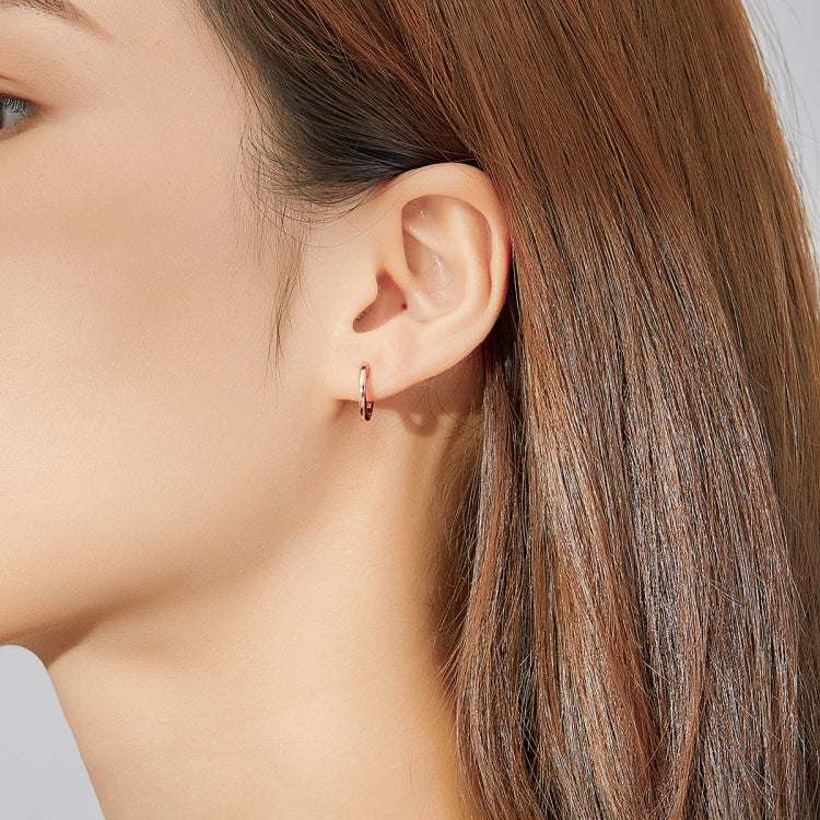 Rose gold hoop earrings worn on ear, hinged back and polished finish