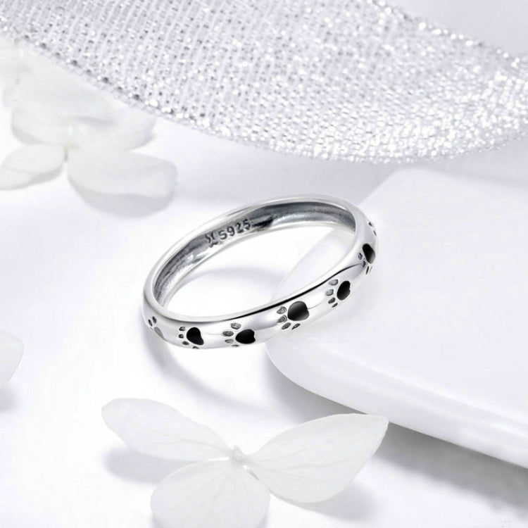 Sterling silver band ring with black paw prints and engraved inner marking