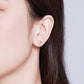 Heart stud earrings on ear: rose gold finish with pink heart CZ