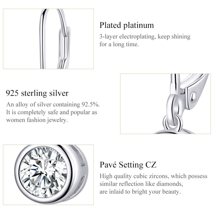 Close-up of round zircon set in sterling silver bezel with hinged hoop
