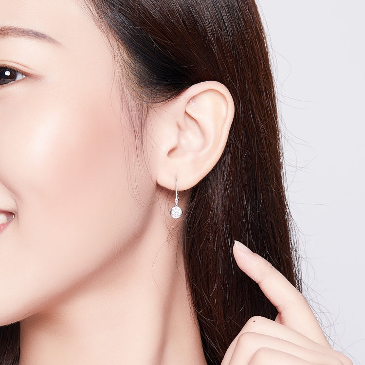 Silver zircon drop earrings on a model, visible round center stone