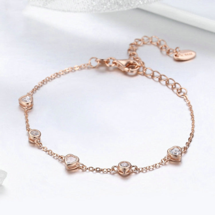 Rose gold plated zircon bracelet close-up with oval crystal stations on slim chain