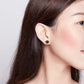 Black enamel paw print stud earring on sterling silver, worn on ear