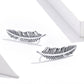 Sterling silver ribbed feather earrings, angled view with hinged hook backs, pair