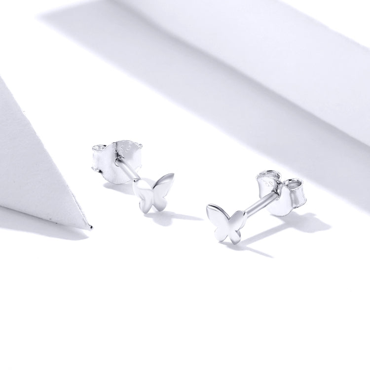 Butterfly stud earrings close-up with silver-toned butterflies and visible metal posts