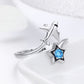 Silver open ring with airplane and star charm, featuring a blue center gem