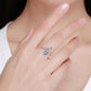 Sterling silver open ring on finger with star design and blue center stone