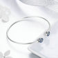 Sterling silver bangle bracelet with two round blue zircon inlaid discs on bar
