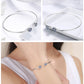 Sterling silver bangle bracelet with two round blue zircon inlaid charms on wrist
