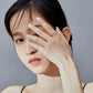 Woman wearing an open silver airplane zircon ring on her finger
