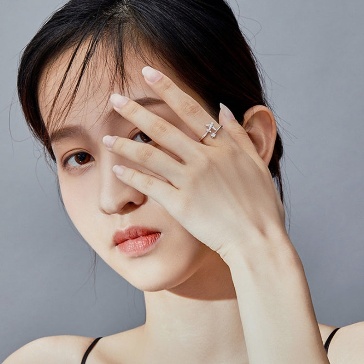 Woman wearing an open silver airplane zircon ring on her finger