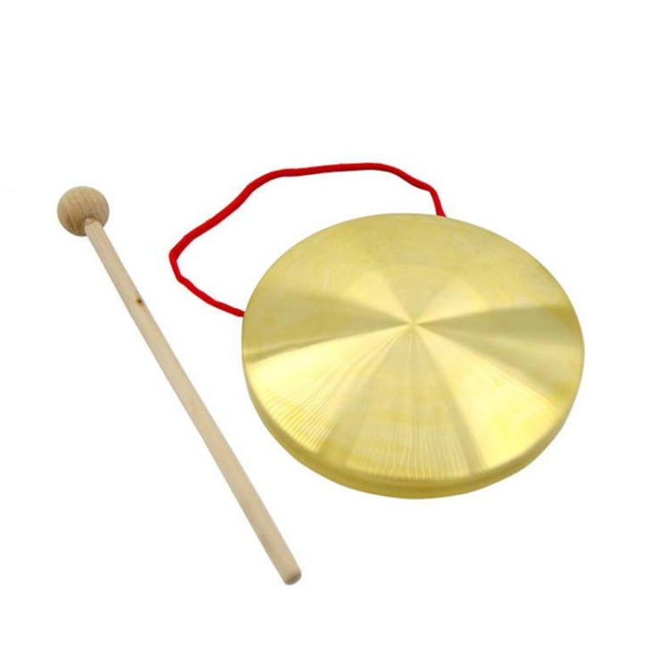 Gold brass hand gong with wooden mallet and red cord in top loop