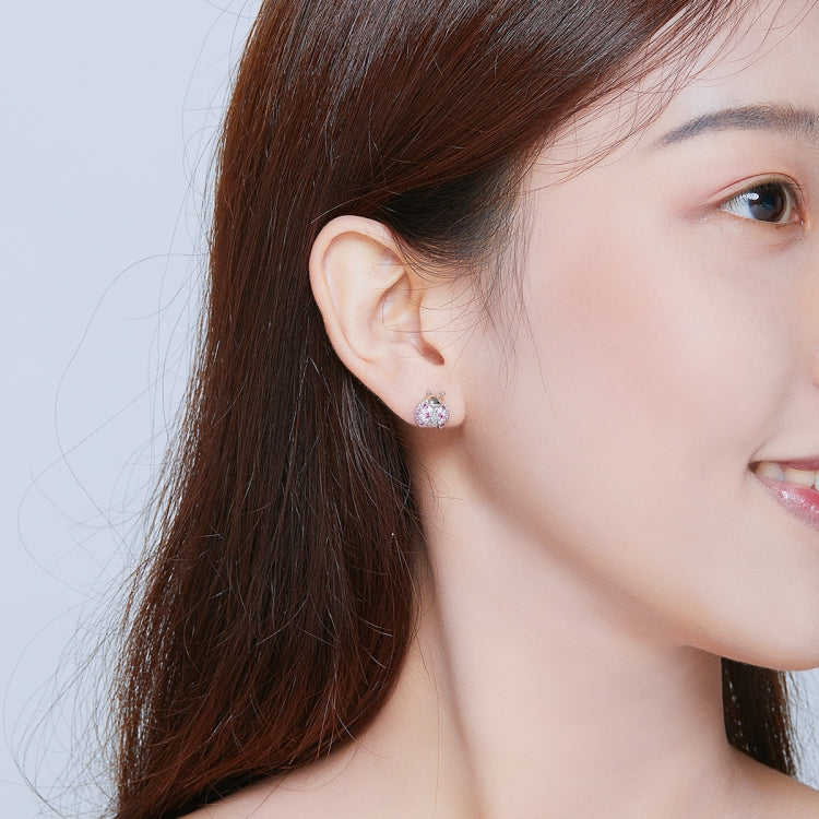 Sterling silver ladybug stud earring worn on a woman's ear