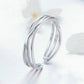 Silver open ring with smooth triple stacked bands and glossy reflective surface