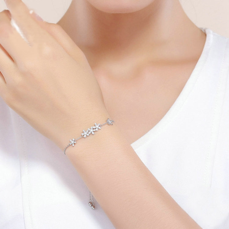 Sterling silver daisy bracelet with flower charms on a wrist