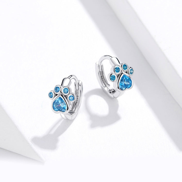 Blue-stone cat paw hoop earrings in sterling silver, angled view on ear
