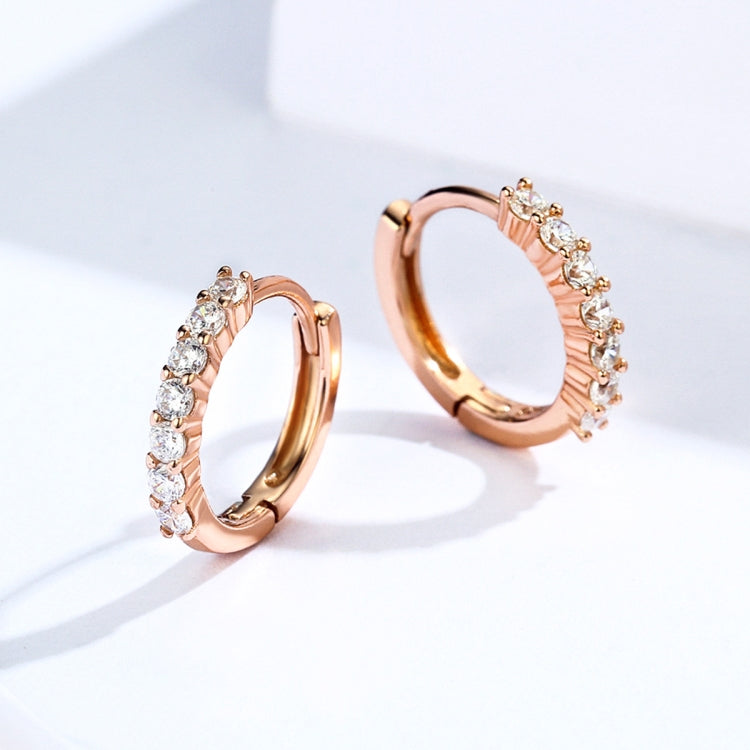Rose gold hoop earrings with zircon-like stones along the curved band