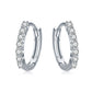 Silver hoop earrings with round zircon-like stones along the hoop edge