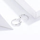 Pair of silver ball hoop earrings with small glossy spheres on the hoop wires