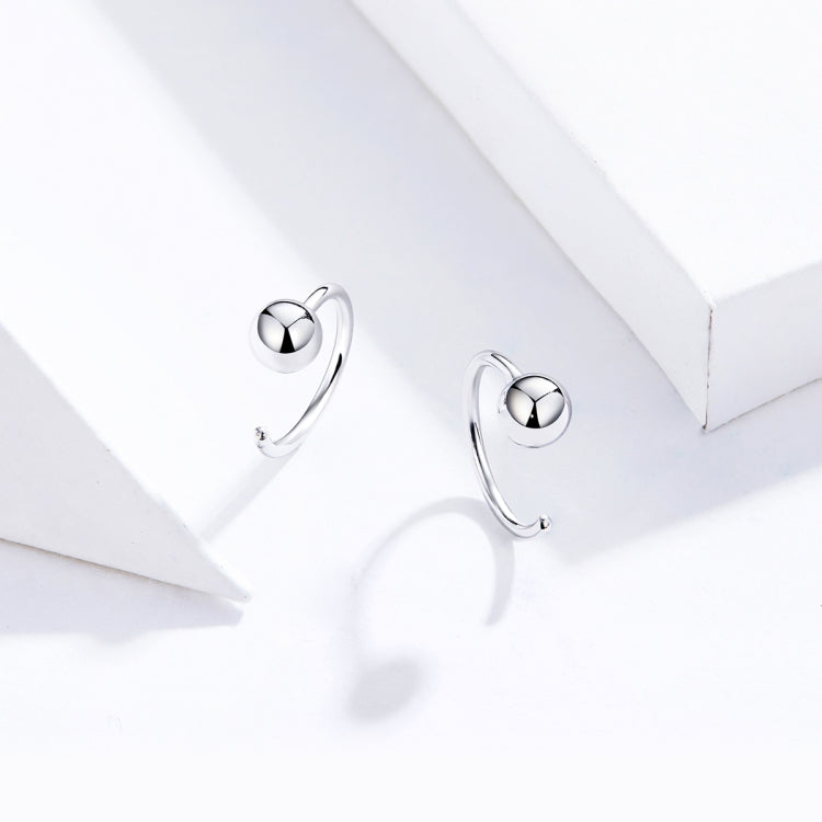 Close-up of silver ball hoop earrings with bright round sphere tops
