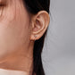 Silver ball hoop earrings worn, featuring small round spheres on hoop wires