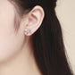 Sterling silver butterfly stud earrings on ear, showing polished wing cutouts