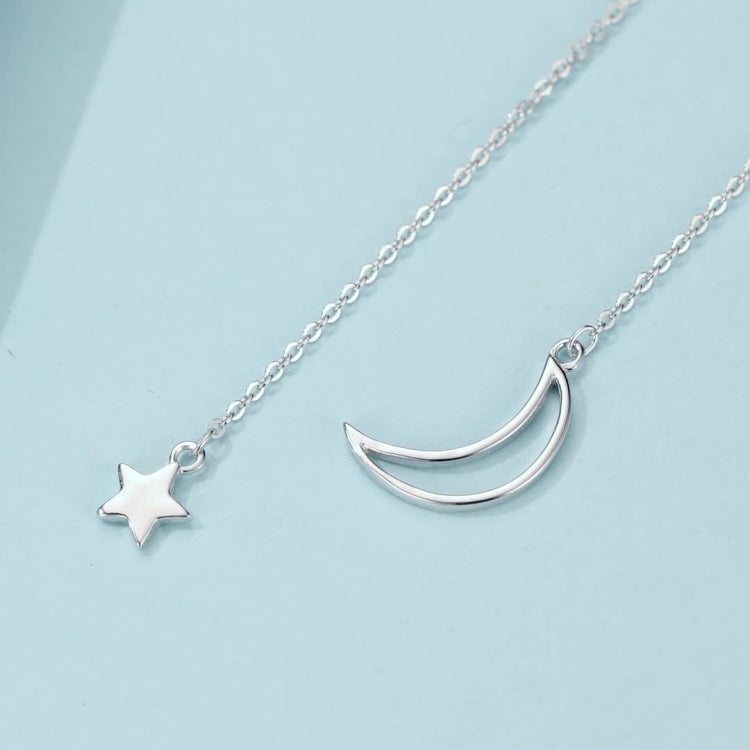Silver-toned necklace with crescent moon and star charms on delicate chain