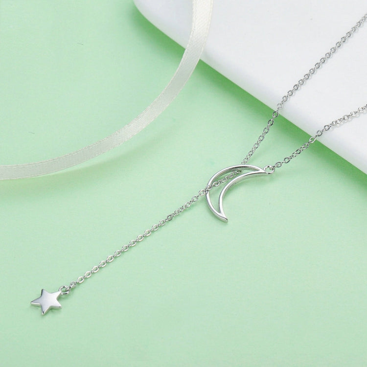 Crescent moon charm and star charm necklace on fine chain, silver-toned