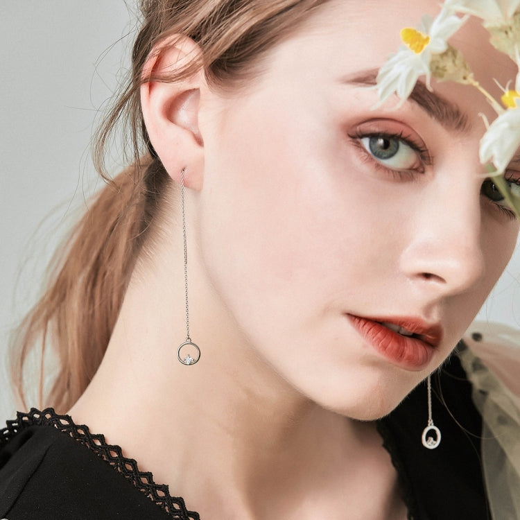 Sterling silver drop earrings on model, round crystal charms with thin chains.
