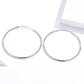 Silver-tone large oval hoop earrings with hinged clasp, angled view