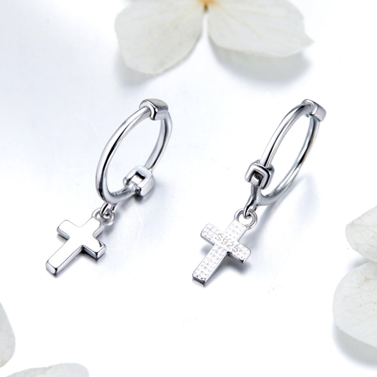 Silver hoop earrings with cross dangle charm and small textured details