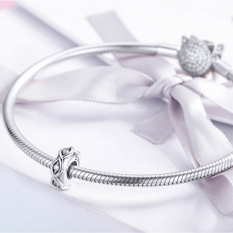 Sterling silver zircon bead charm on a coiled bracelet with bow ribbon
