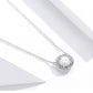 Silver chain necklace with round zircon halo pendant centerpiece, side view