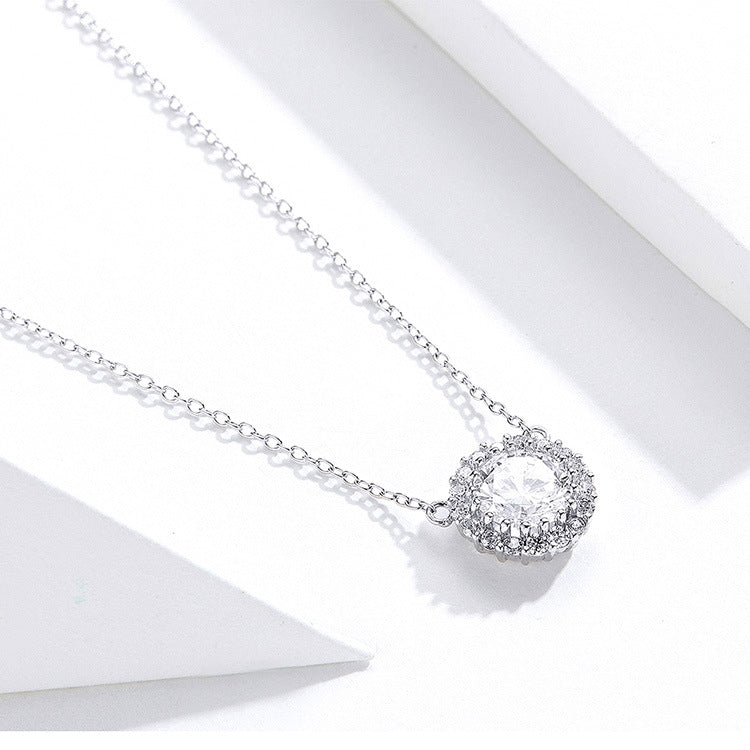 Silver chain necklace with round zircon halo pendant centerpiece, side view