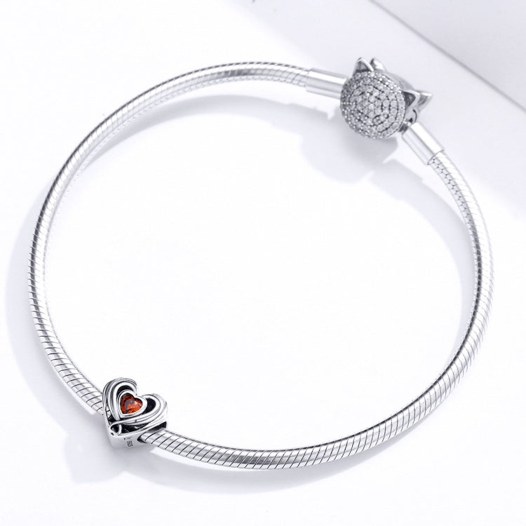 Silver snake-chain bracelet with heart charm bead featuring orange CZ heart center