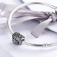 Sterling silver heart charm bead on a silver charm bracelet with a ribbon bow