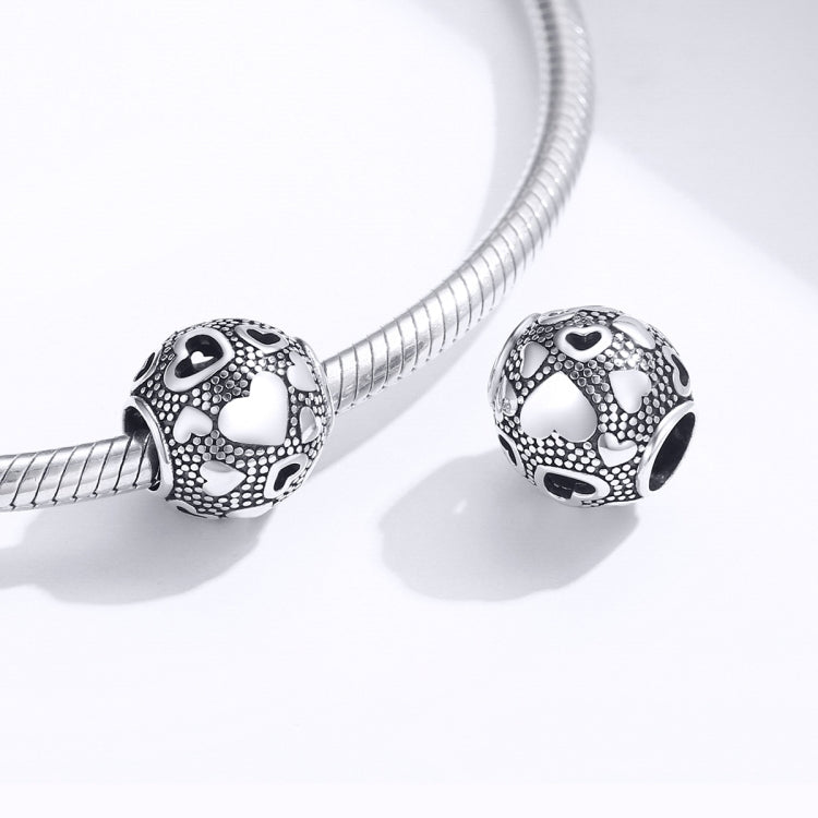 Pair of round sterling silver heart-pattern bead charms with black enamel on snake chain